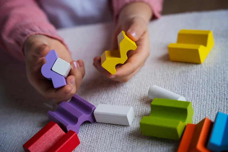 Criança brincando com blocos coloridos de encaixe durante uma avaliação
